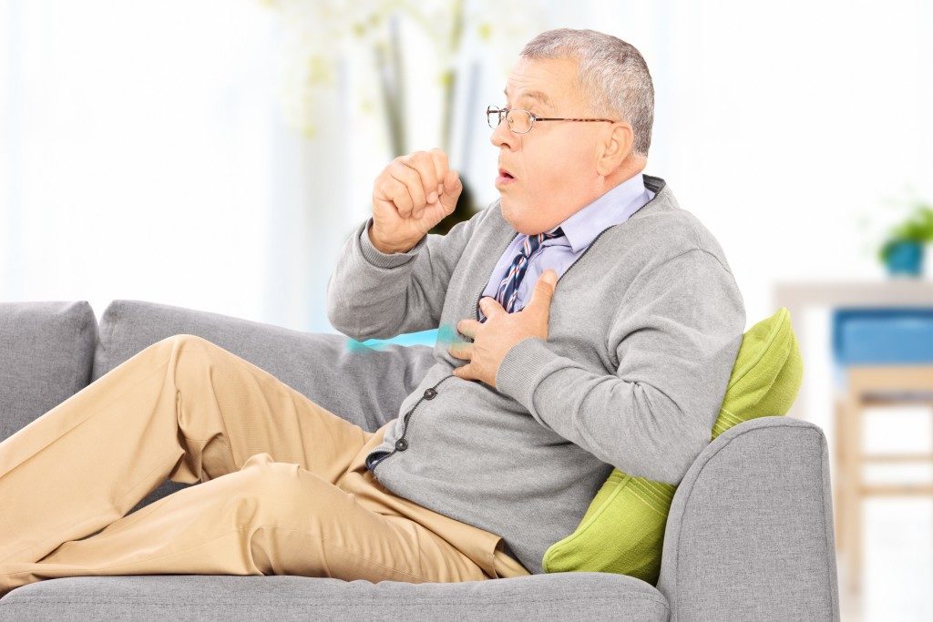 Photo of an elderly man coughing
