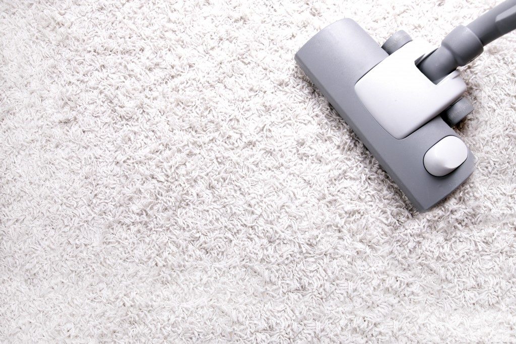 Vacuuming an off white carpet