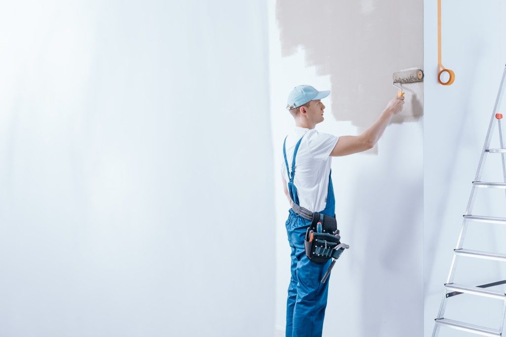Worker painting the white walls