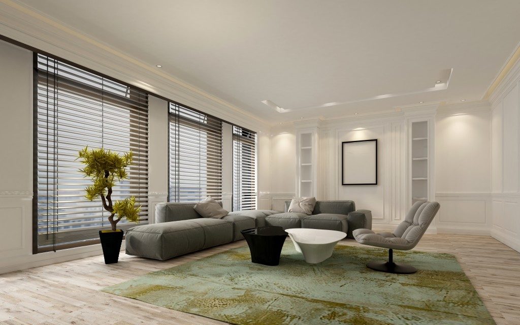 living room with windows located at the east side, green carpet and grey sofas