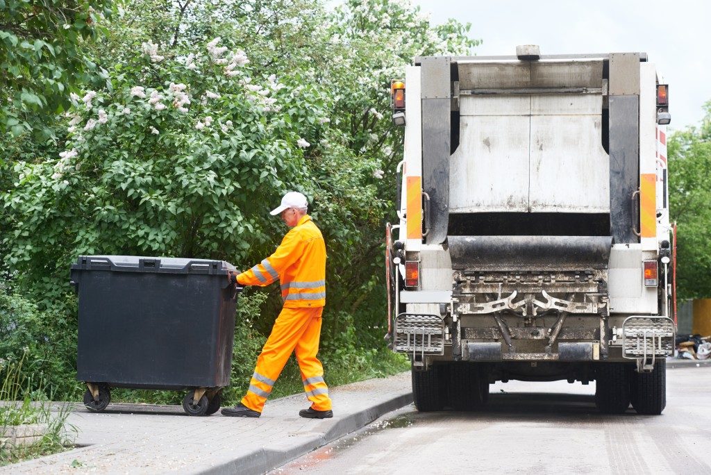 Garbage collector pulling the trash bin