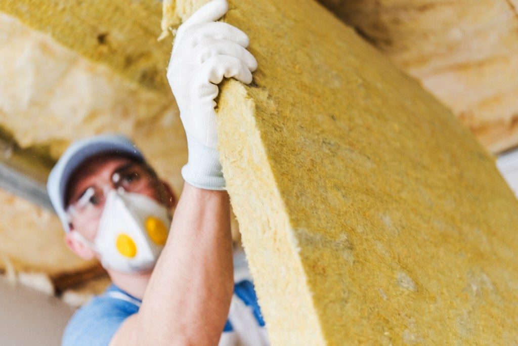 Worker insulating a home