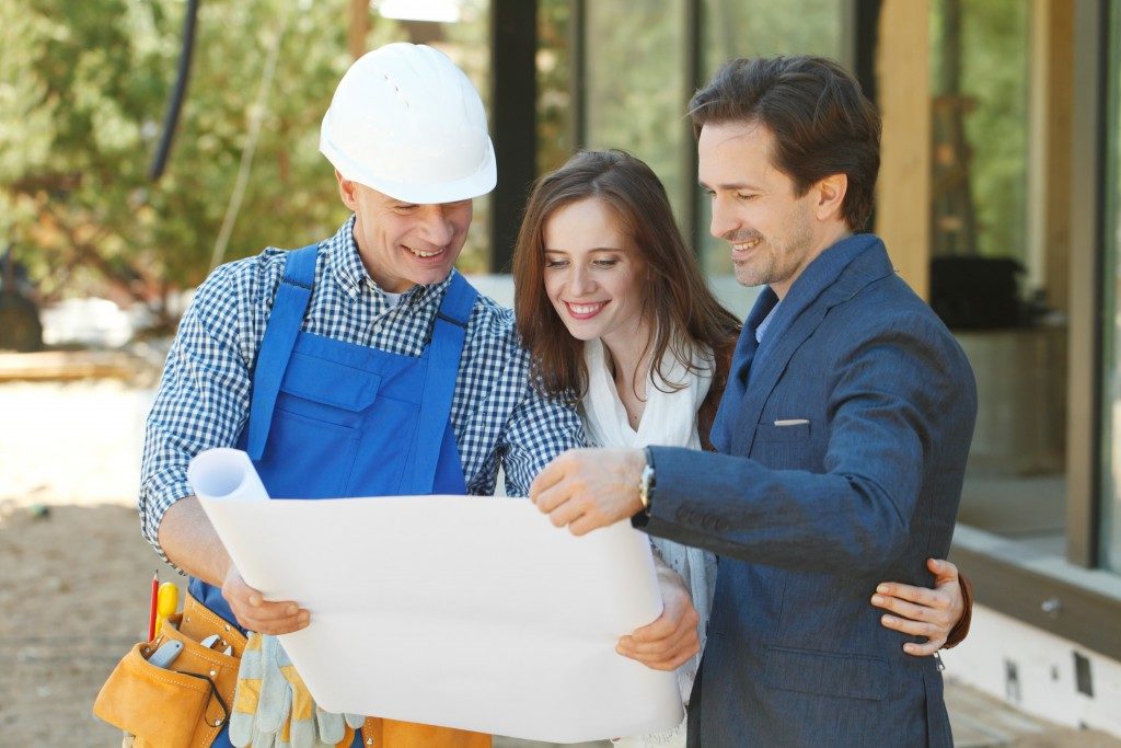 contractor showing paper to couple
