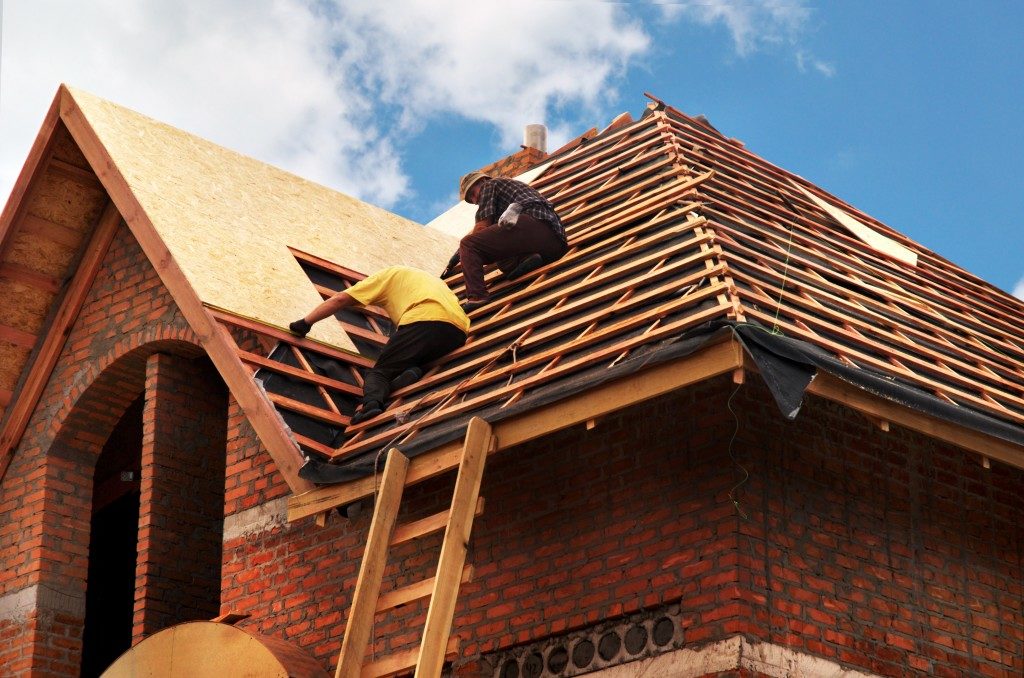men building a roof over the house