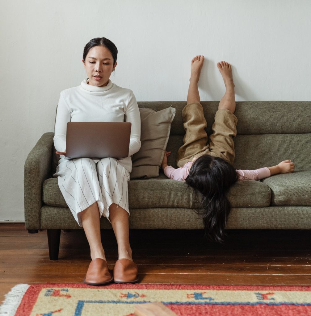 woman working from home on the couch with daughter