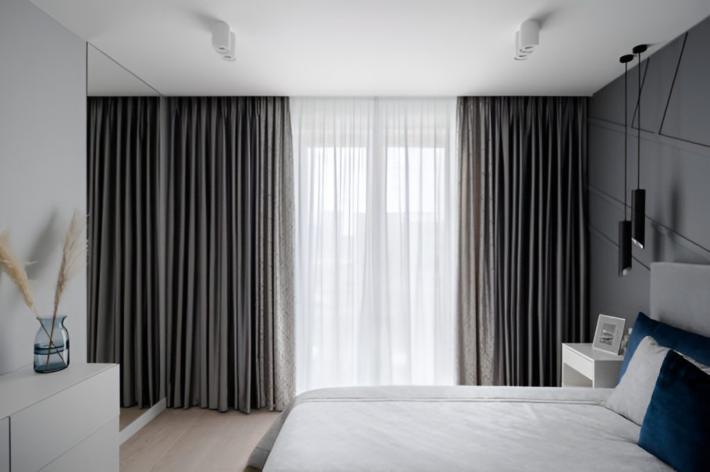 modern bedroom with gray blackout curtains over sheer curtains