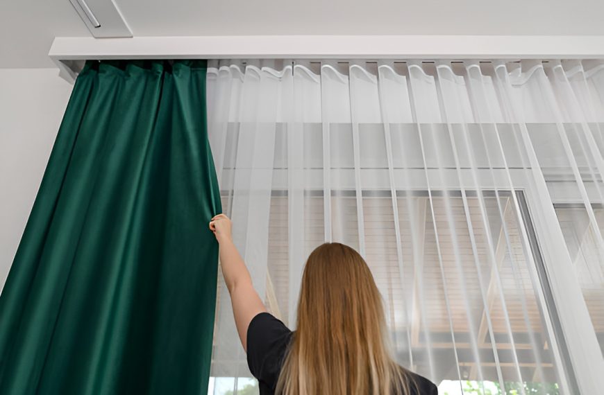 woman closing blackout curtains over sheer curtains
